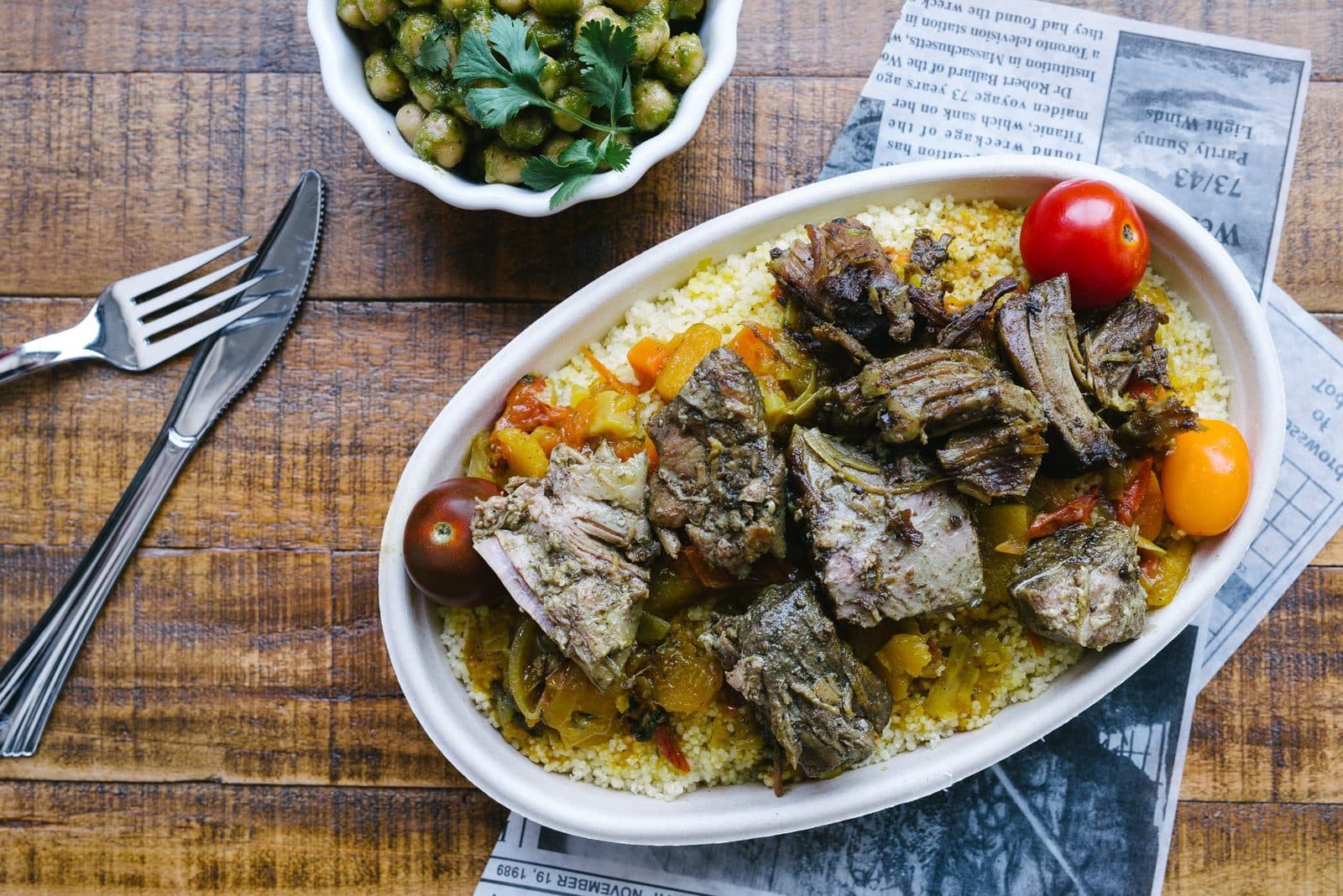 Slow cooked lamb over yellow couscous with roasted vegetables and cherry tomatoes